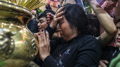Crowds of people jostle to collect ashes for good luck at Ba Binh Duong Pagoda