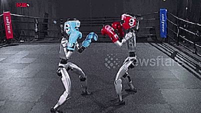 ヒューマノイドロボットがリングで熱心にトレーニングし、ボクサーのようにパンチを繰り出す