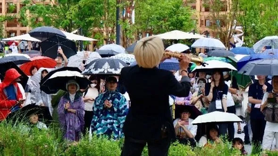 日本の観客は雨の中、ベトナムのサックス奏者の演奏を鑑賞した