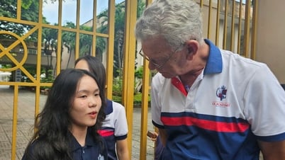 Maestra occidental con más de 6 años de experiencia aplaudiendo y esperando a los candidatos a graduarse frente a la puerta de la escuela.