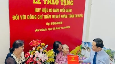 호치민시 당위원회 신임 서기인 쩐 루 꽝이 100세 당원에게 80년 당원 배지를 수여하고 있다.