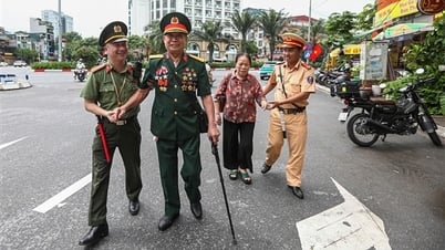 退役軍人たちは旗や花の間を歩きながらパレードを見守った