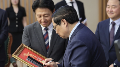 El Primer Ministro firma una placa conmemorativa por la producción del teléfono número 2 mil millones de Samsung Vietnam.