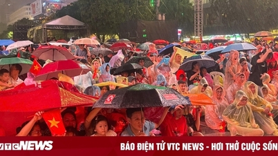 Penonton Kota Ho Chi Minh menantang hujan untuk menyaksikan program seni dalam rangka merayakan Hari Nasional