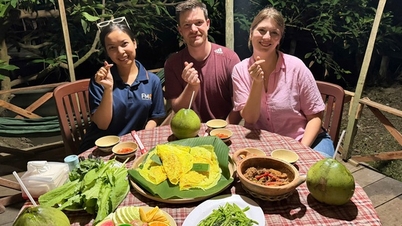 Turistas estrangeiros desfrutam da experiência de cozinhar pratos do oeste do Vietnã em Can Tho.