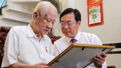Le Quoc Phong, a Ho Si Minh-városi Pártbizottság állandó titkárhelyettese átadja a 80 éves párttagsági jelvényt Thoi Anban.