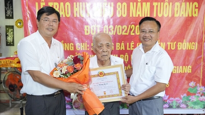 Secretarul partidului din provincia Giang, Nguyen Tien Hai, îi înmânează insigna de membru de partid cu 80 de ani de experiență în partid unui membru veteran al partidului, la domiciliul acestuia.