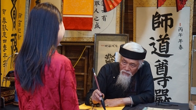 Un vieux calligraphe est assis à écrire des calligraphies tandis que de la musique de DJ et des danseurs se produisent.