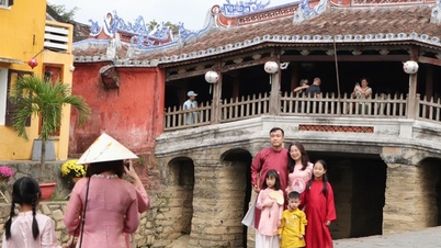 Hagyományos ao dai ruhákba öltözött turisták jelentkeznek be Hoi Anban a holdújév (a ló éve) 29. napján.