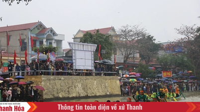Folk trotsar regnet för att titta på den traditionella båtkappseglingsfestivalen i Trung Chinh kommun.