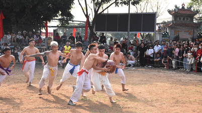 Para pemuda bertelanjang dada bergulat dengan bola seberat 20 kg dalam festival desa Thuy Linh.