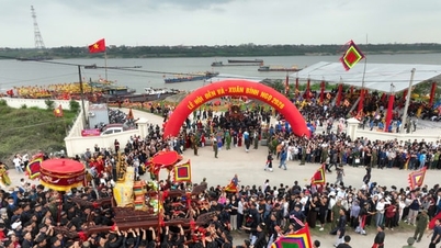 Uma procissão solene do palanquim sagrado atravessando o rio durante o Festival do Templo Va.