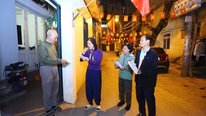 Gece geç saatlerde, Hanoi'deki mahalle yetkilileri kapı kapı dolaşarak seçmen kartları dağıtıyor.