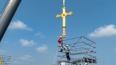 El momento en que las dos cruces doradas fueron devueltas a lo alto de la catedral de Notre Dame en Saigón.