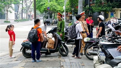 Tampilan jarak dekat polisi lalu lintas Hanoi yang memeriksa dan memberikan sanksi kepada orang tua karena parkir ilegal saat mengantar dan menjemput anak-anak mereka dari sekolah.