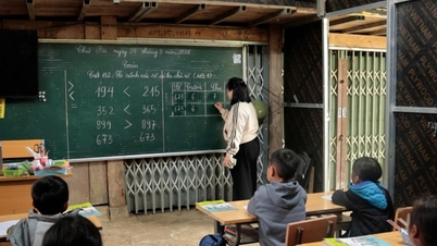 Veintiún niños se agrupan para estudiar bajo el alero de un aula improvisada en medio de una zona propensa a los deslizamientos de tierra.