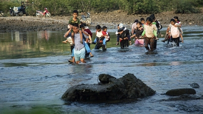 ອູ້ມລູກຂ້ອຍຂ້າມແມ່ນໍ້າໄປໂຮງຮຽນ.