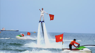 Turistler, Da Nang plajı üzerindeki flyboard gösterisinden gözlerini alamıyorlar.