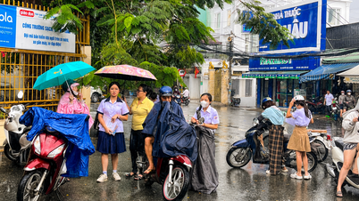 Ho Chi Minh City: Kandydaci spieszą się na miejsce egzaminu z języka obcego w deszczu.