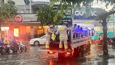 ตำรวจจราจรใช้ยานพาหนะพิเศษในการขนส่งผู้คนข้ามถนนที่ถูกน้ำท่วมอย่างหนักท่ามกลางฝนตกหนักในนครโฮจิมินห์