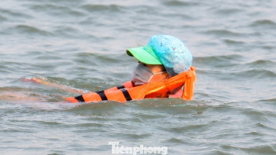 Dengan mengenakan topi dan masker untuk mendinginkan badan, mereka pergi ke Sungai Lam untuk berenang.
