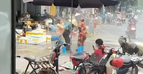 Dispute over selling space escalates: Seafood vendor sprays high-pressure water in the face of vegetable vendor.
