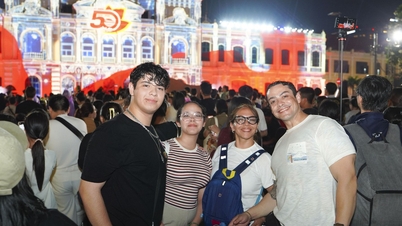 Mii de localnici și turiști au înfruntat ploaia pentru a urmări o cartografiere 3D în fața sediului Comitetului Popular din orașul Ho Chi Minh.